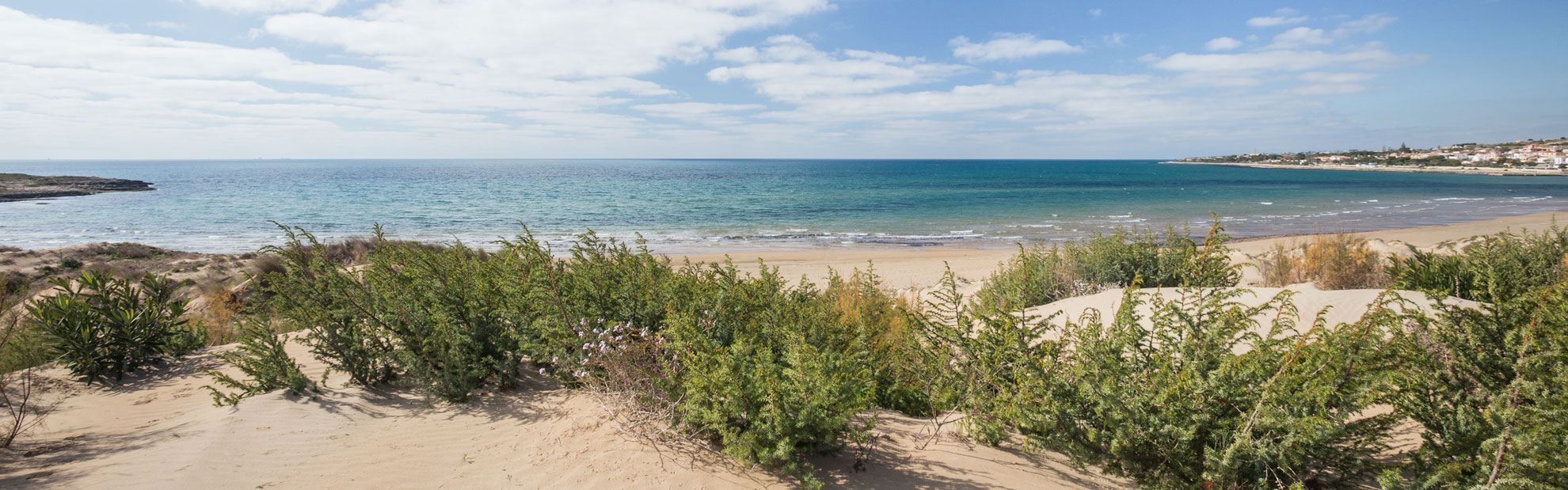 Spiaggia di Marina di Modica con dune, vegetazione mare e cielo con nuvole